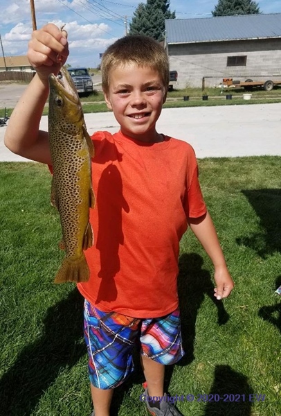 Boy with fish, building behind